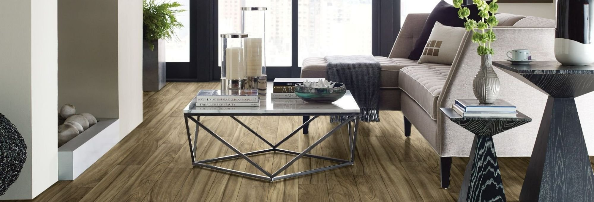 beige couch and black coffee table in living room area with brown laminate floor from Wholesale Flooring and Blinds in Casper, WY