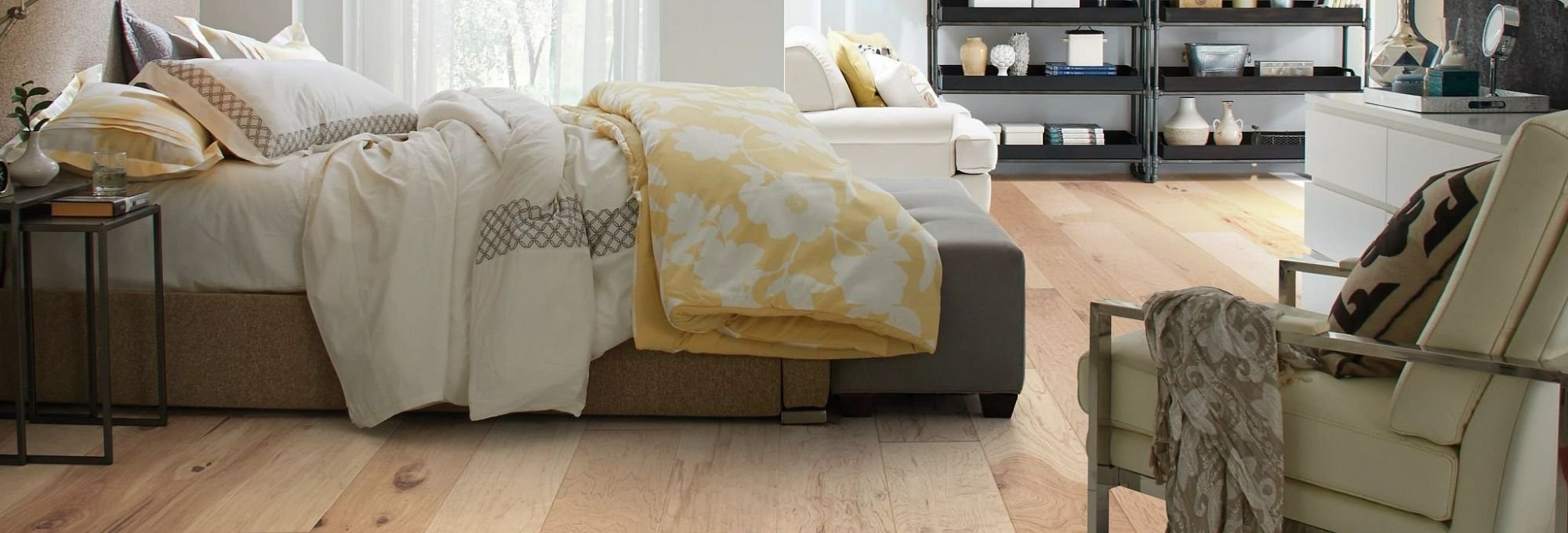 white bed and beige chair in bedroom with brown hardwood floor from Wholesale Flooring and Blinds in Casper, WY