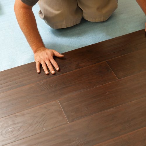 Person installing hardwood flooring - Flooring installation services from Wholesale Flooring and Blinds in Casper, WY